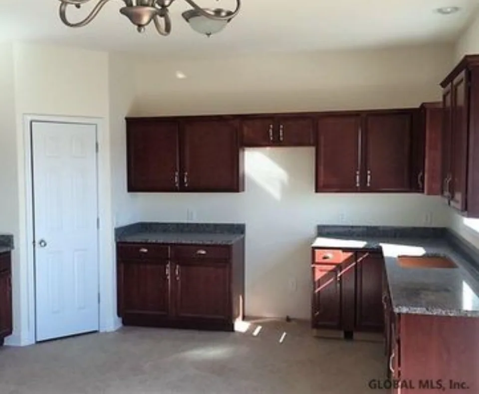 Before: kitchen with dark wood cabinets, painted backsplash walls, and an open space for the range.